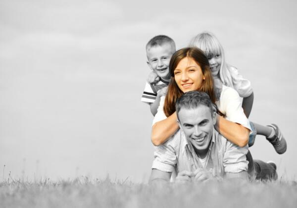 Cheerful Family On Beautiful Summer Meadow Enjoying And Having Fun