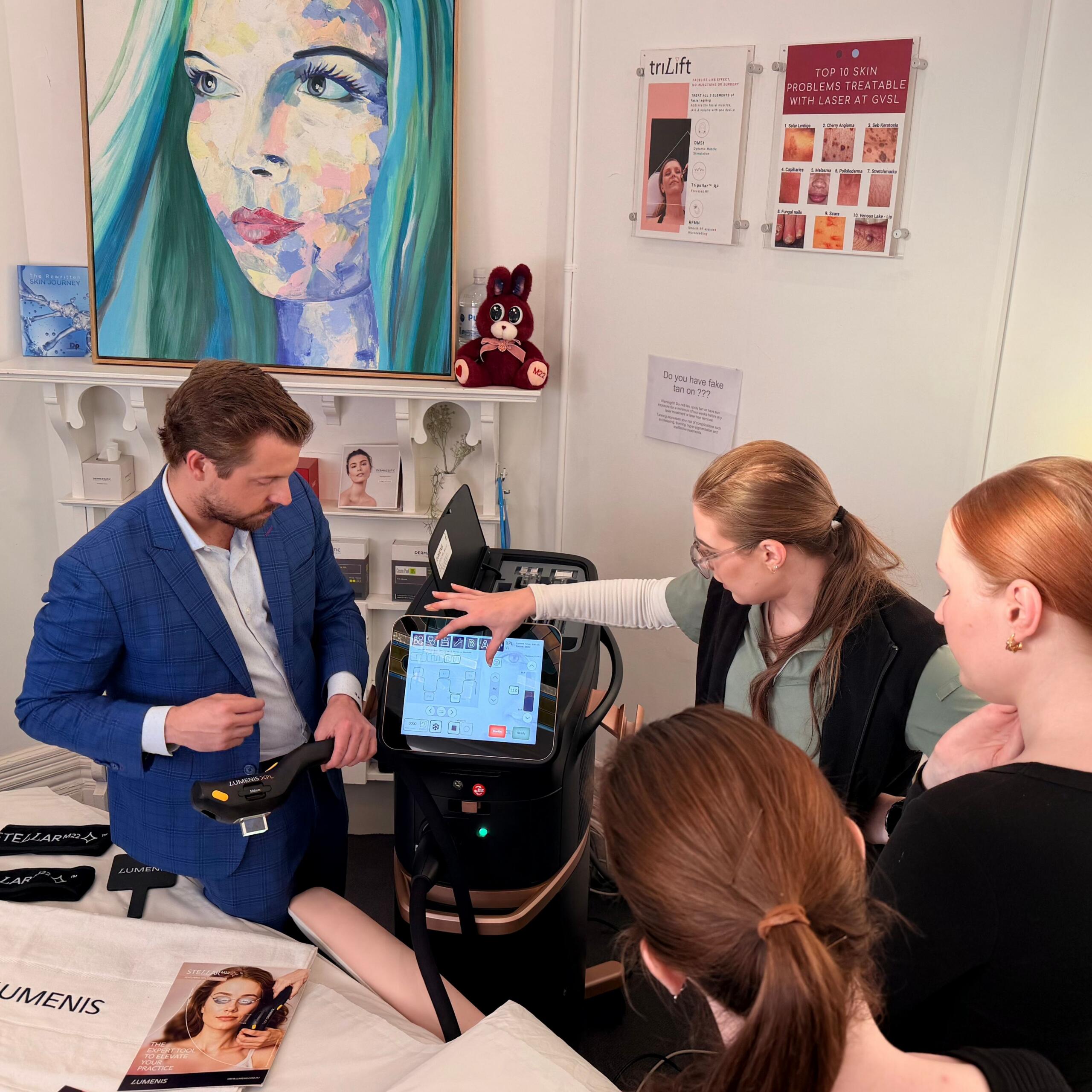 "Lumenis trainer demonstrating the Stellar M22 XPL handpiece and touchscreen to a group of GVSL practitioners during an in-clinic training session